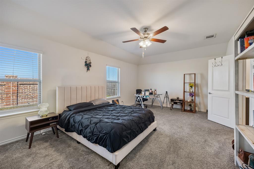 620 Gunsmoke Trail Princeton, TX 75407 - Photo 17 of 37 a spacious bedroom with a bed a window and a chandelier