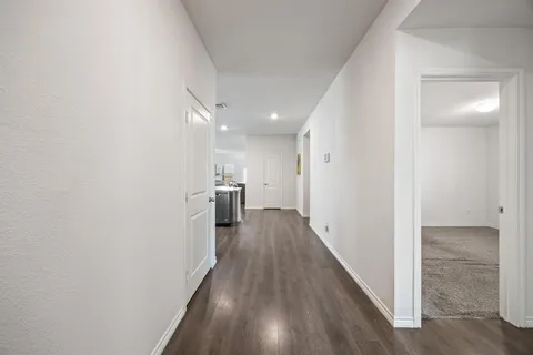 a view of a hallway with wooden floor