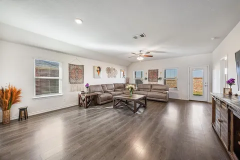 a living room with furniture and a wooden floor
