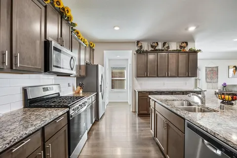a kitchen with a stove sink and cabinets