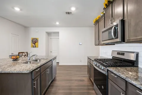a kitchen with stainless steel appliances granite countertop a sink stove and refrigerator
