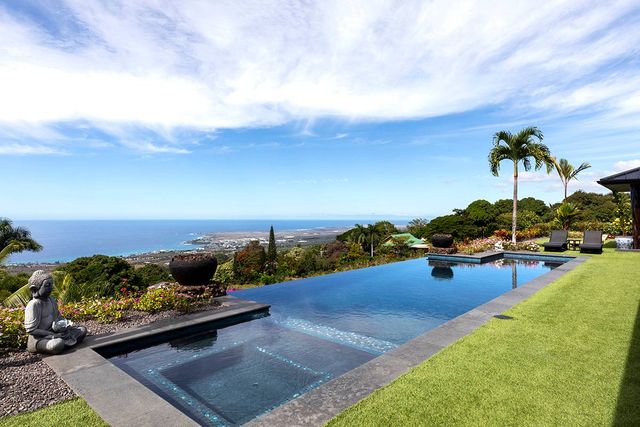 a view of a backyard with couches and swimming pool in back