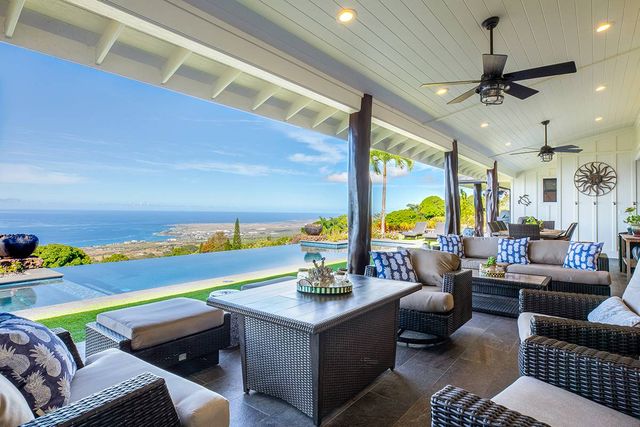 a living room with patio furniture and a potted plant