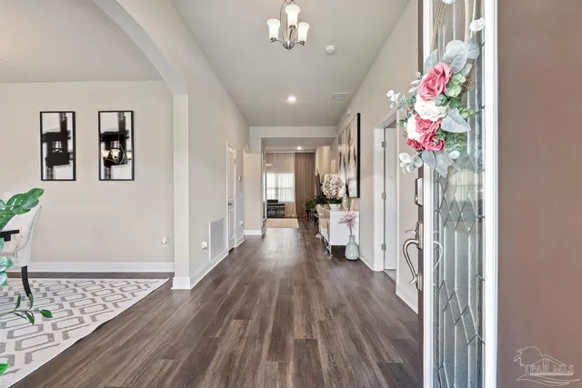 a living room with furniture a chandelier and a flat screen tv