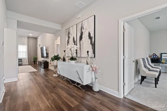 a living room with furniture kitchen view and a flat screen tv