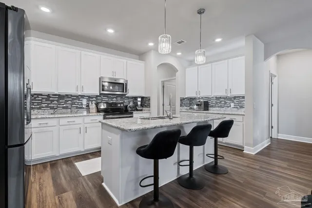 a kitchen with stainless steel appliances granite countertop a stove and a microwave