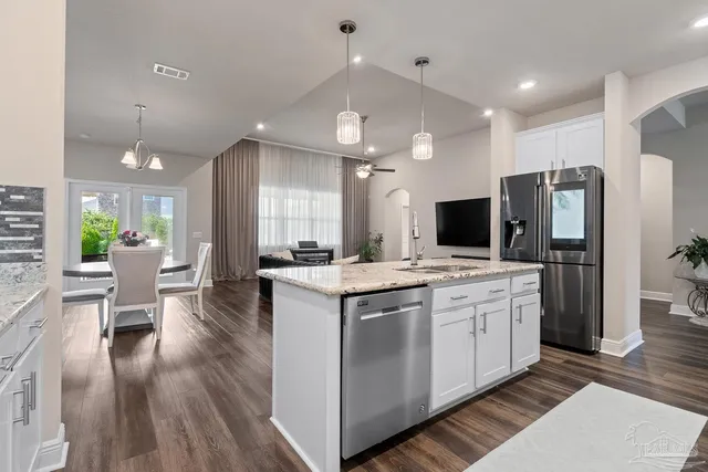 a view of cabinets a sink wooden floor and a window