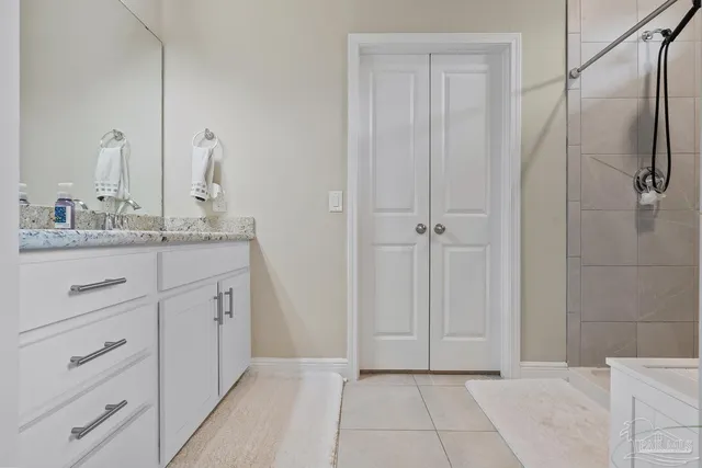 a en suite bathroom with a granite countertop sink and a mirror