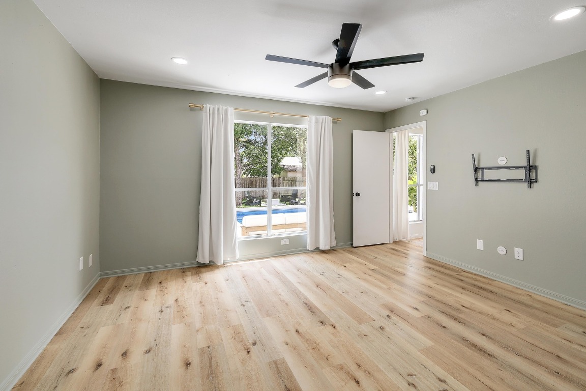 1205 Rambling Trail Cedar Park, TX 78613 - Photo 13 of 38 Primary bedroom suite from primary bathroom entrance. West Elm window treatments with linen blackout curtains. Recessed lighting and ceiling fan. View of back yard pool.