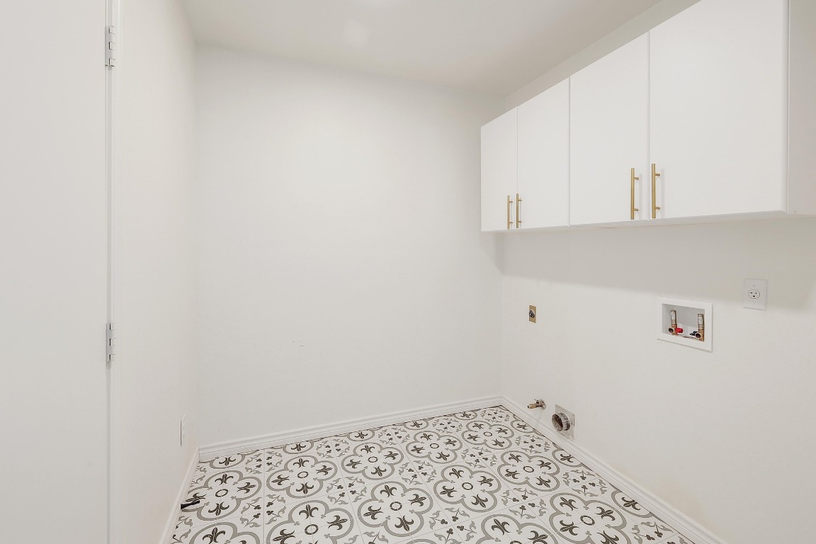 1205 Rambling Trail Cedar Park, TX 78613 - Photo 21 of 38 Dedicated laundry room off entry and garage, featuring electric and gas dryer hookup, washer hookup, wall-mounted cabinet storage space, designer tile floor