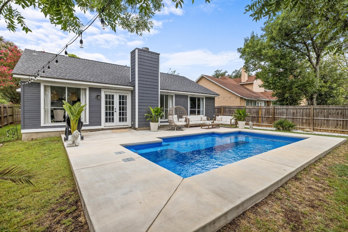 1205 Rambling Trail Cedar Park, TX 78613 - Photo 24 of 38 View of swimming pool from deep end and rear of home with french doors, outdoor lounge area, patio, and fenced backyard.