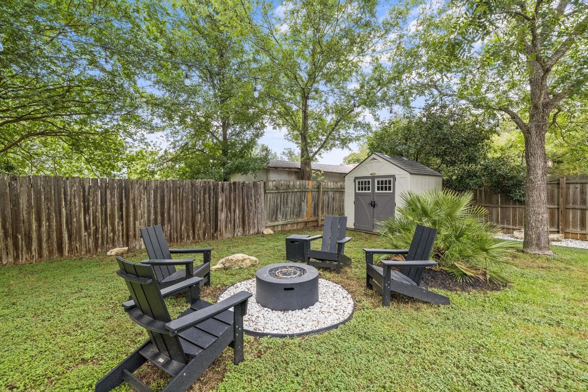 1205 Rambling Trail Cedar Park, TX 78613 - Photo 28 of 38 View of fenced yard space featuring fire pit lounge area, trees, and Suncast storage shed.