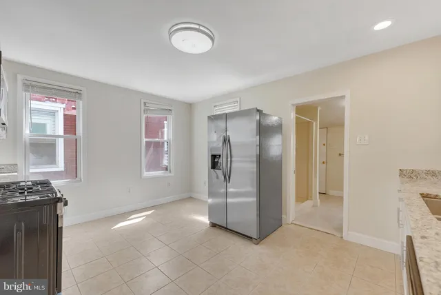 a kitchen with stainless steel appliances granite countertop a refrigerator and a stove top oven