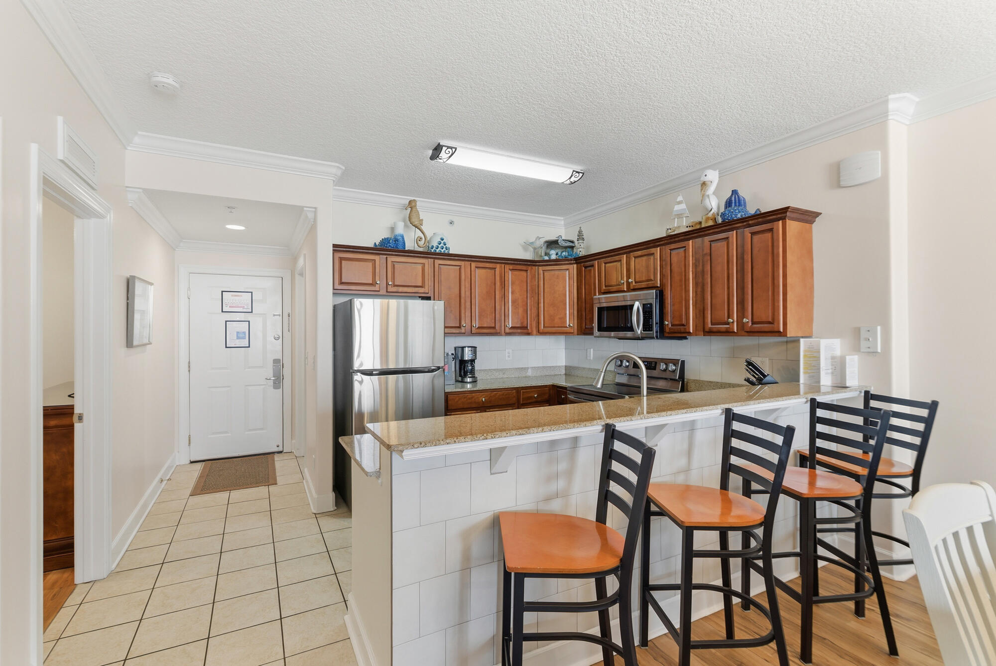 17643 Front Beach Road, Unit 1806 Panama City Beach, FL 32413 - Photo 17 of 25 a kitchen with stainless steel appliances a refrigerator and a stove top oven