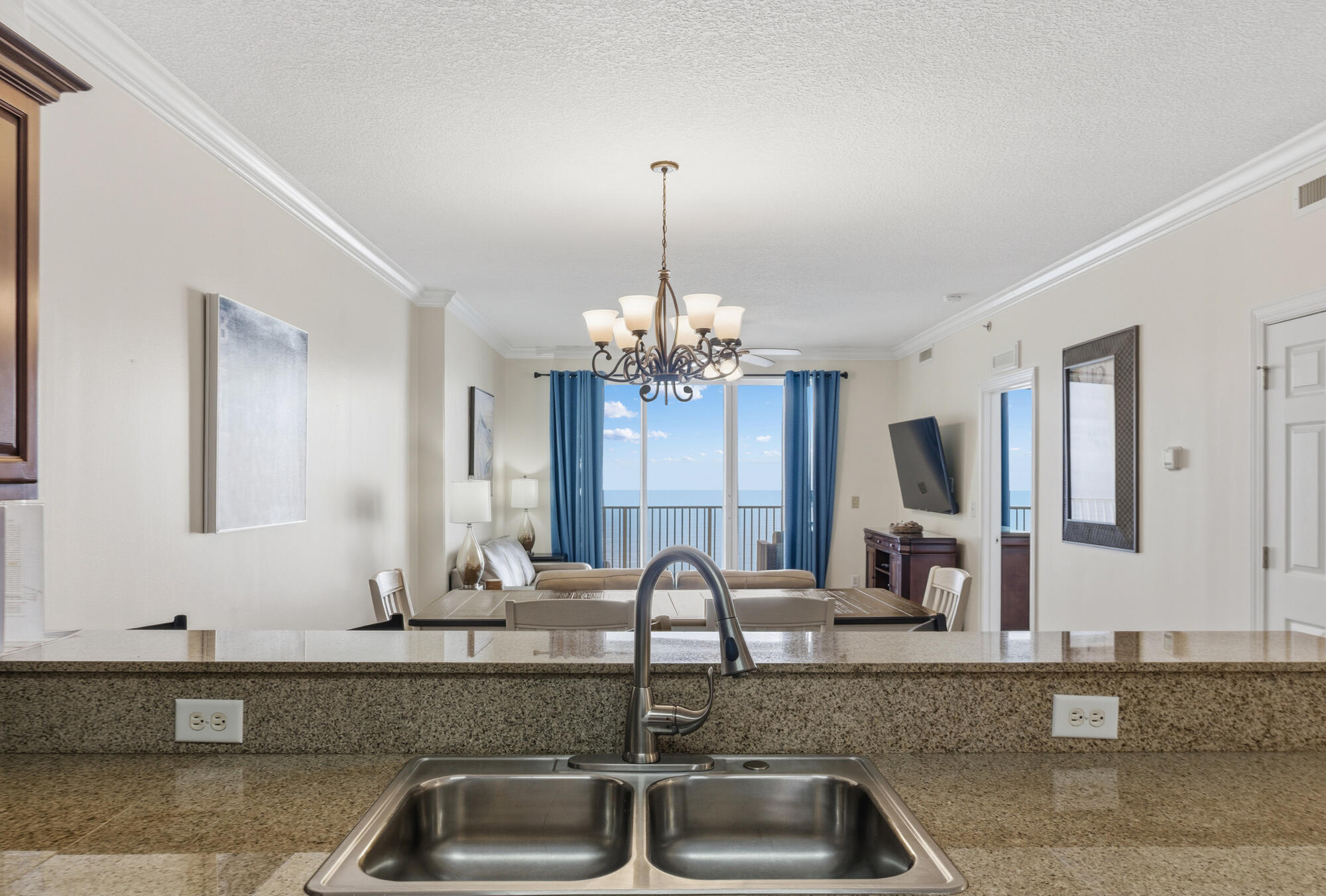 17643 Front Beach Road, Unit 1806 Panama City Beach, FL 32413 - Photo 18 of 25 a kitchen with granite countertop a sink and a large mirror