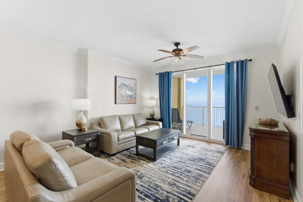 17643 Front Beach Road, Unit 1806 Panama City Beach, FL 32413 - Photo 4 of 25 a living room with furniture a large window and a flat screen tv
