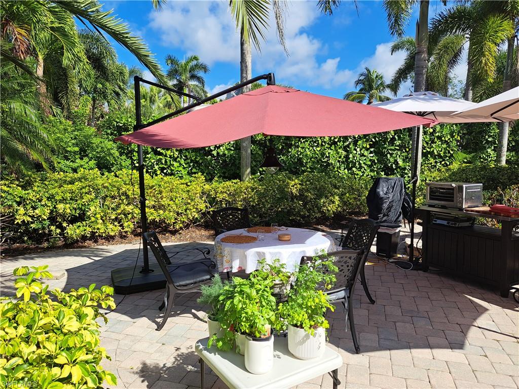 4928 Coach Lane Naples, FL 34114 - Photo 11 of 20 a view of a patio with table and chairs potted plants