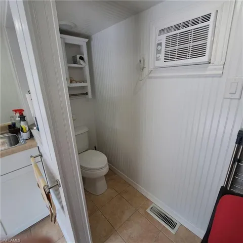 a white toilet sitting next to a sink and a mirror