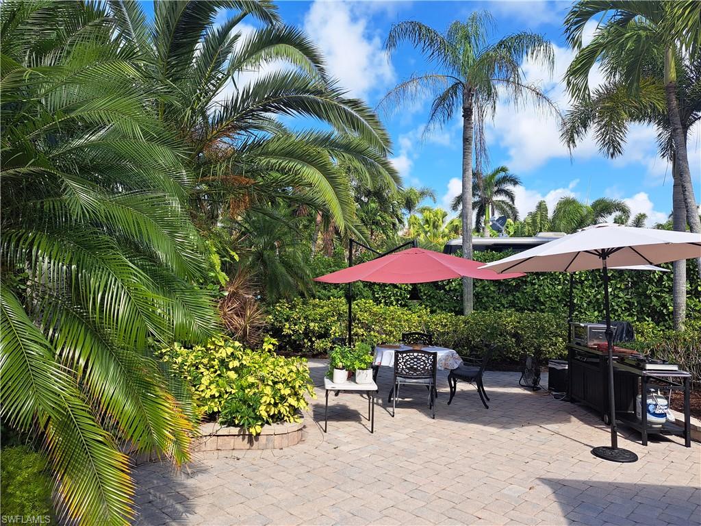 4928 Coach Lane Naples, FL 34114 - Photo 9 of 20 a view of a patio with a table and chairs under an umbrella