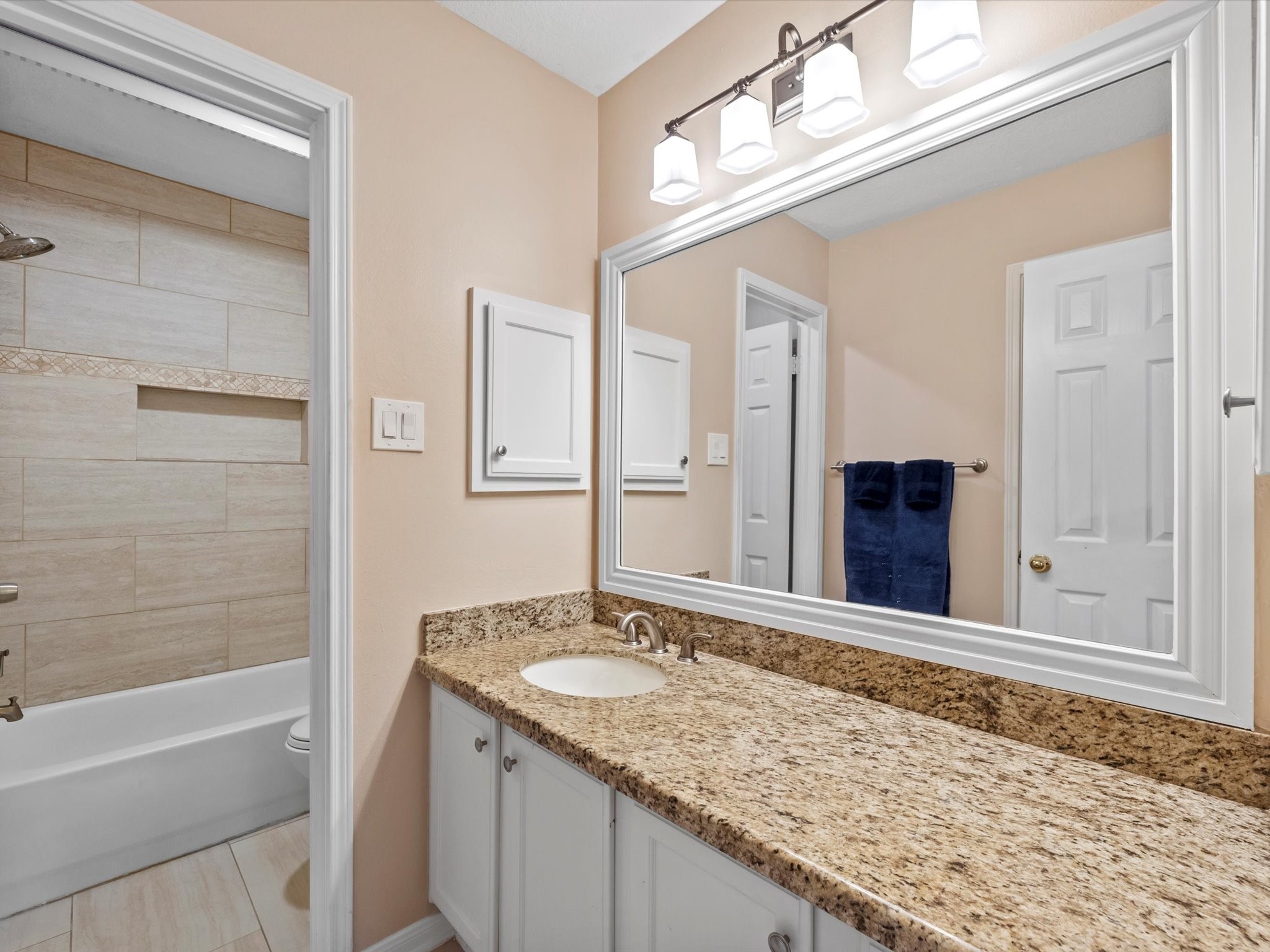 911 Chinni Court Houston, TX 77094 - Photo 26 of 31 a bathroom with a granite countertop sink and a mirror