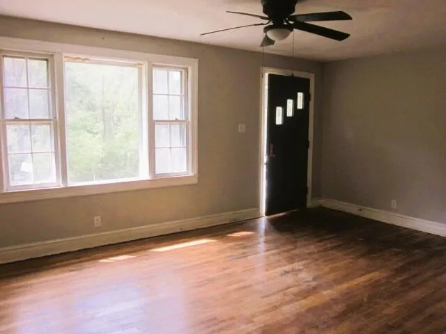 an empty room with a window and a ceiling fan