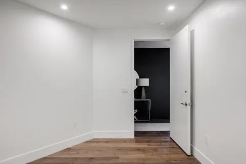 an empty room with wooden floor and closet