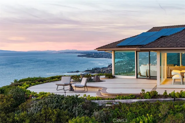 a view of a house with lawn chairs and wooden fence