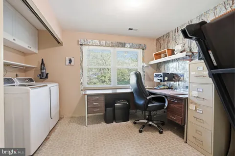 a view of a workspace with furniture and a window