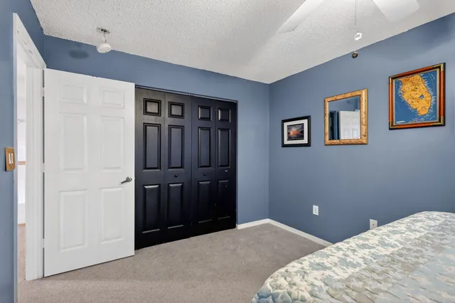 a bedroom with a bed and painting on the wall