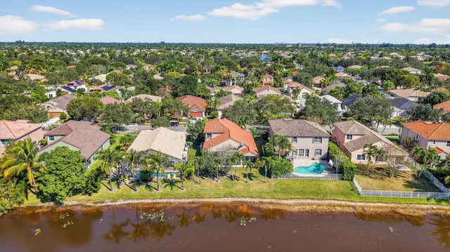 an aerial view of residential houses with outdoor space and trees