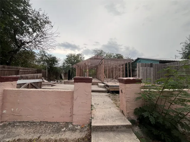 a view of a patio with couches and table and chairs with wooden fence