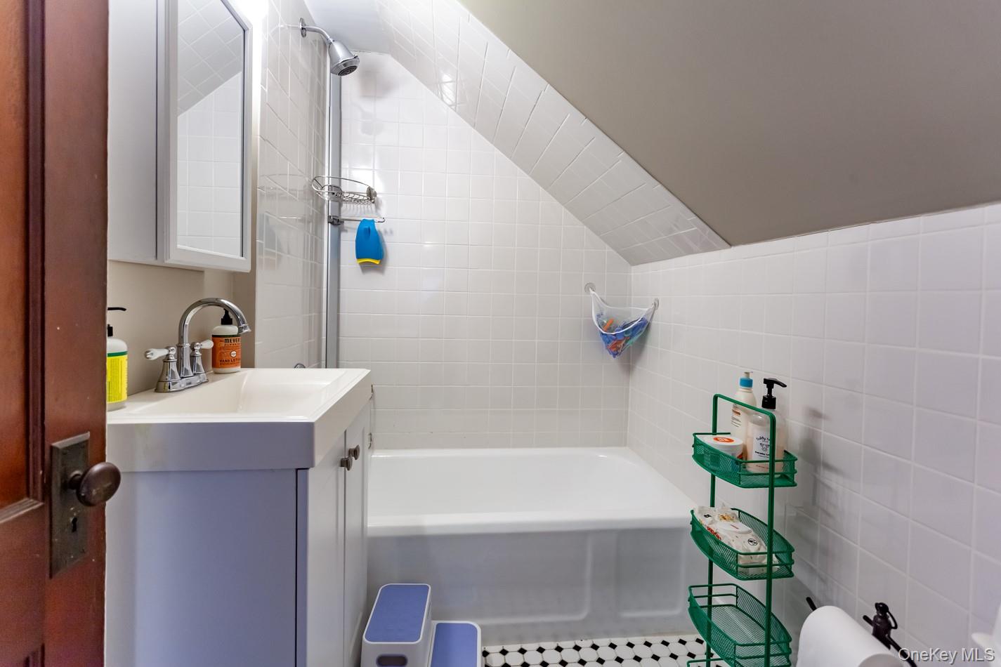 1710 Highway 9D Cold Spring, NY 10516 - Photo 16 of 41 Full bath featuring vanity, tile walls, lofted ceiling, and shower / washtub combination