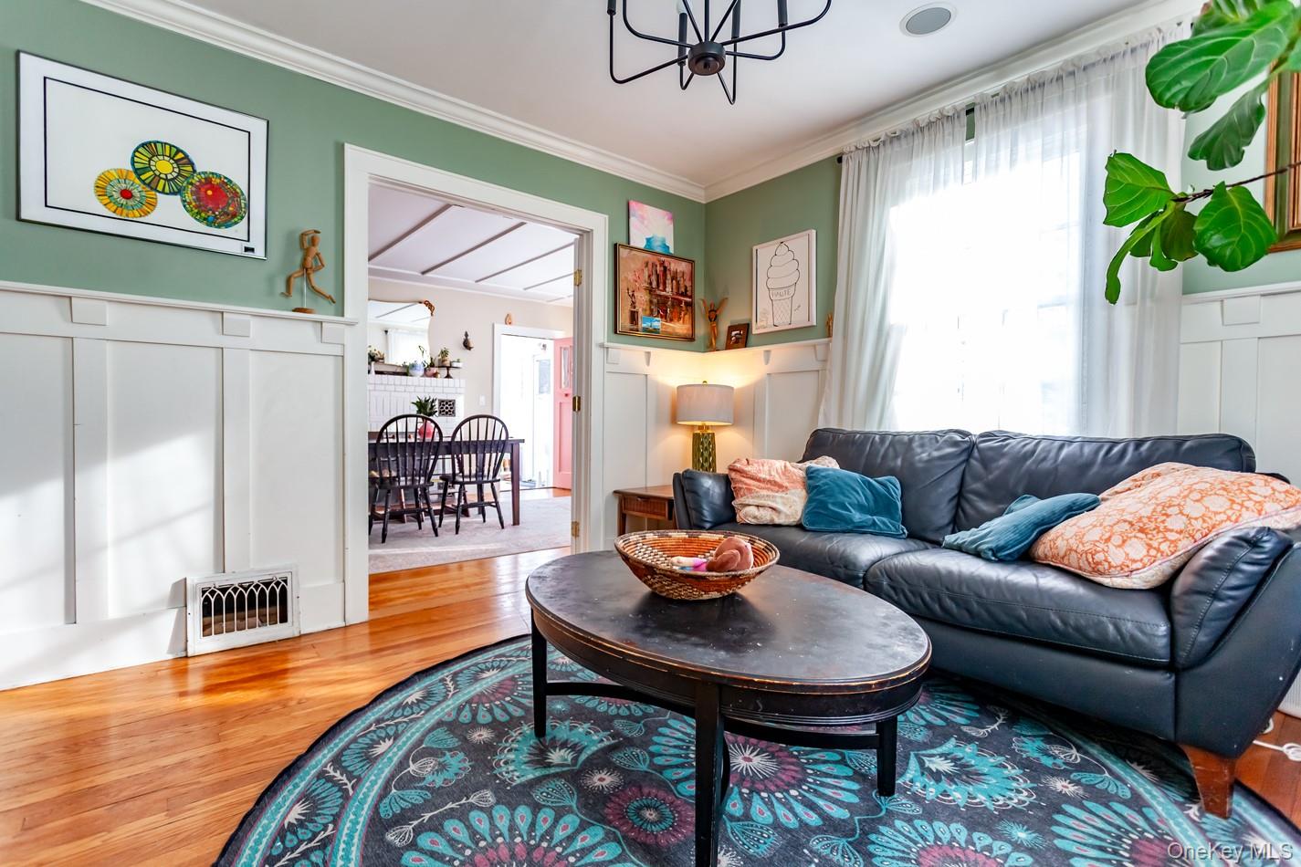 1710 Highway 9D Cold Spring, NY 10516 - Photo 32 of 41 Living area with wood finished floors, a chandelier, crown molding, and a decorative wall