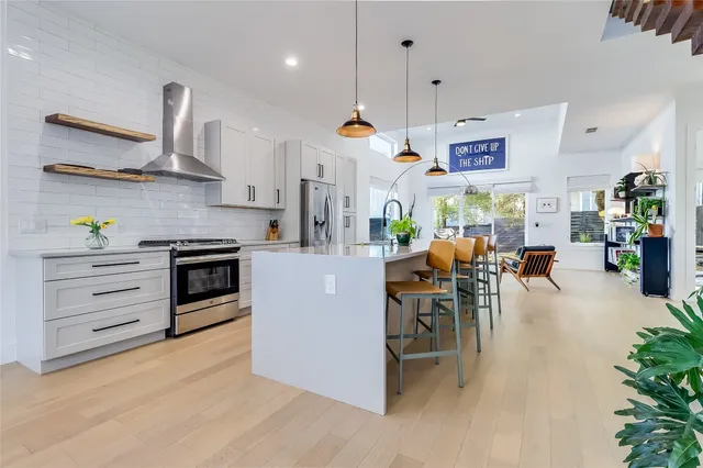 a kitchen with kitchen island granite countertop stainless steel appliances lots of counter space and wooden floor