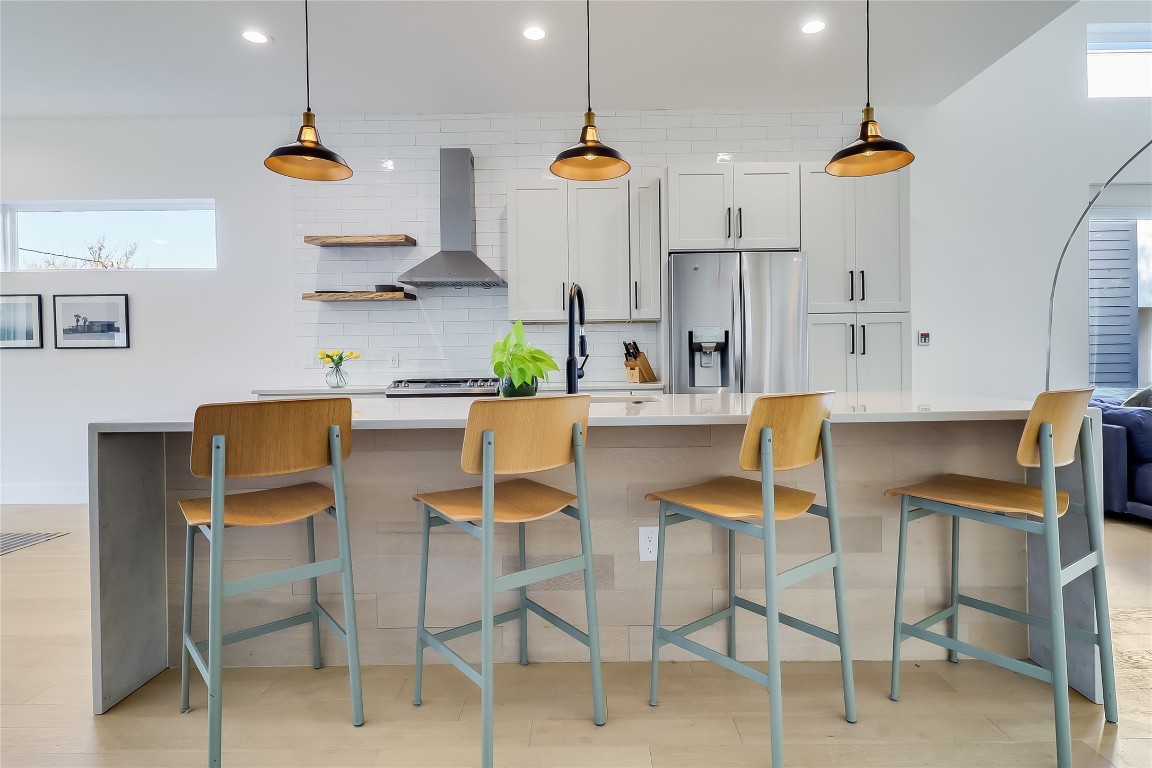 4712 Reyes Street, Unit 1 Austin, TX 78721 - Photo 14 of 40 a kitchen with stainless steel appliances kitchen island granite countertop dining table chairs and a sink