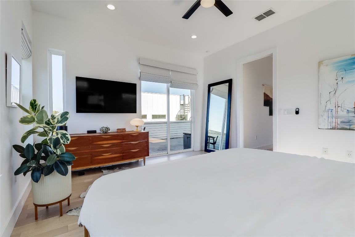 4712 Reyes Street, Unit 1 Austin, TX 78721 - Photo 21 of 40 a bedroom with a bed and a flat screen tv