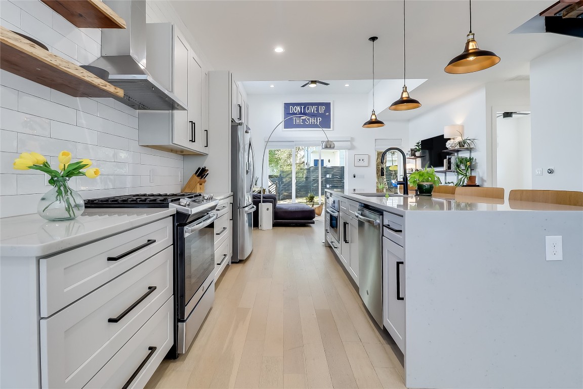 4712 Reyes Street, Unit 1 Austin, TX 78721 - Photo 7 of 40 a kitchen with kitchen island granite countertop stainless steel appliances lots of counter space and wooden floor