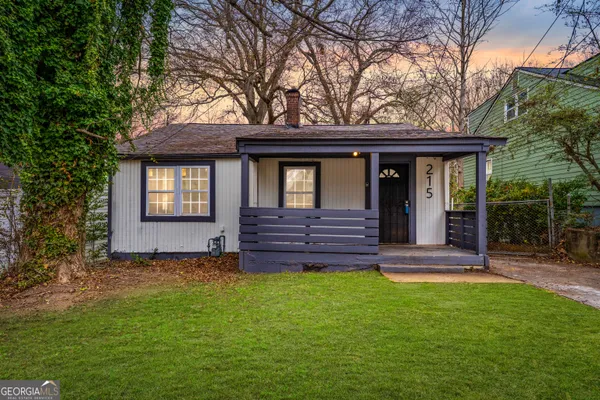 a view of a house with a yard and tree