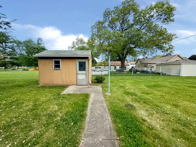 a view of a backyard with table and chairs and a large tree