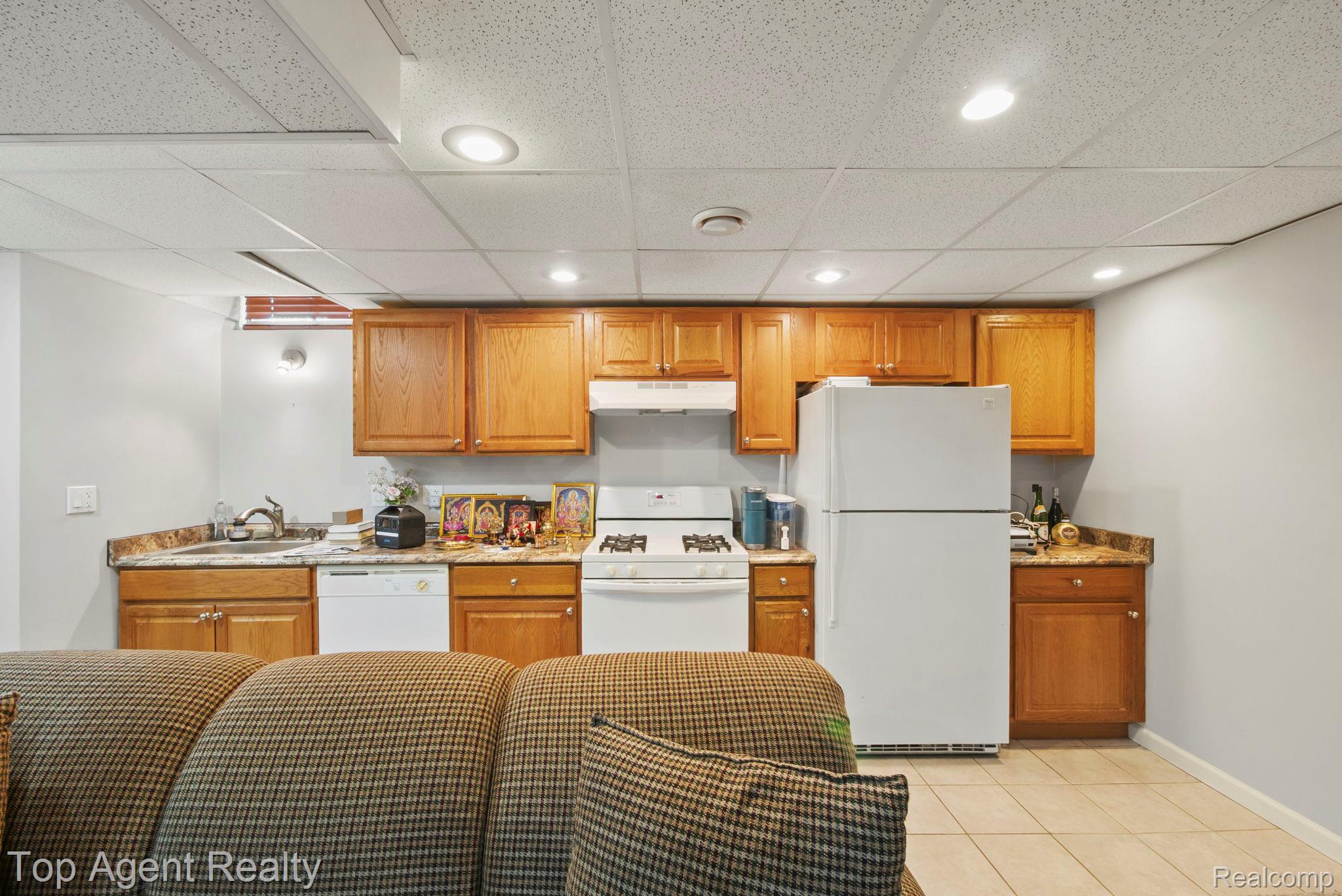41567 Glade Road, Unit 20 Canton, MI 48187 - Photo 34 of 47 Kitchen with white appliances, a paneled ceiling, wood finish cabinets, light tile patterned floors, and recessed lighting