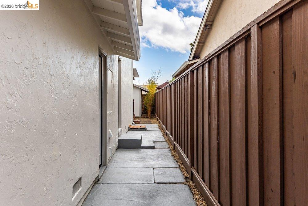 1298 Ribbon Street Foster City, CA 94404 - Photo 69 of 86 Side yard walkway featuring concrete pavers, gravel accents, and a wood privacy fence