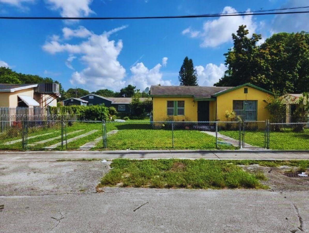 2365 Northwest 79th Terrace Miami, FL 33147 - Photo 3 of 3 a view of a house with a big yard and palm trees