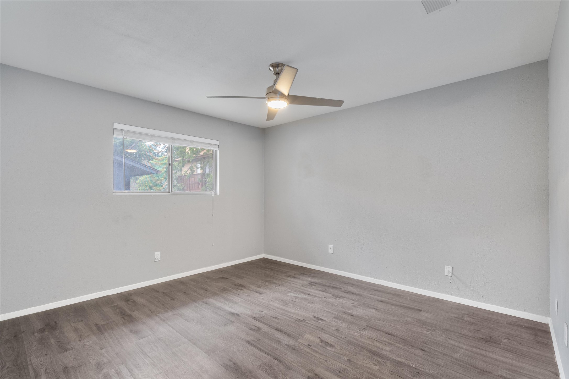 3415 Menchaca Road, Unit 113 Austin, TX 78704 - Photo 11 of 21 an empty room with wooden floor ceiling fan and window