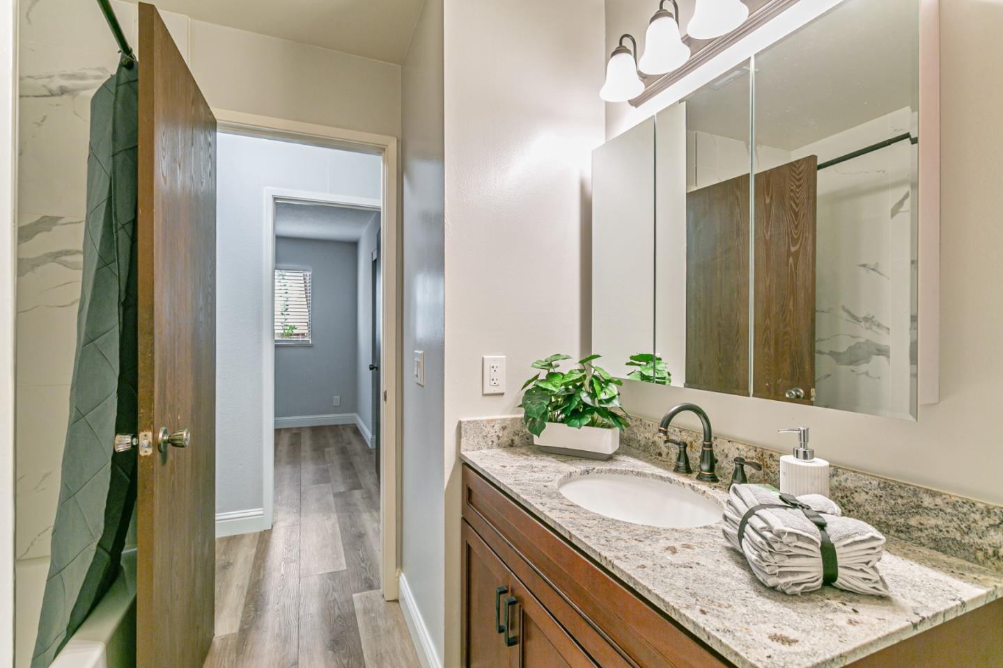 970 Ortega Circle Gilroy, CA 95020 - Photo 21 of 26 a bathroom with a granite countertop sink a mirror and a shower
