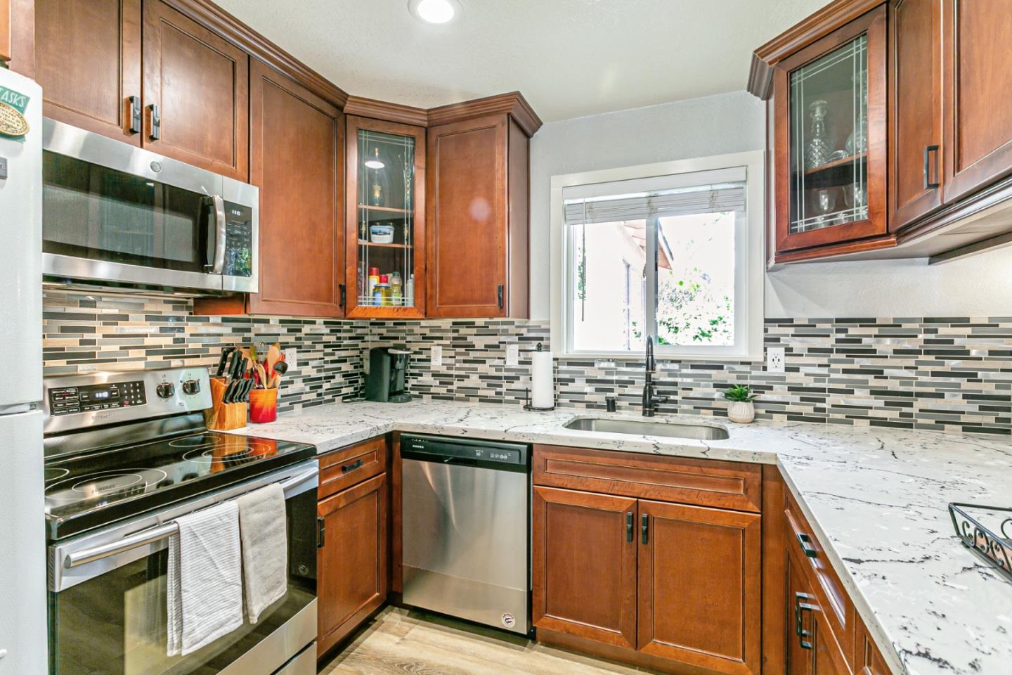 970 Ortega Circle Gilroy, CA 95020 - Photo 7 of 26 a kitchen with stainless steel appliances granite countertop a sink stove and microwave