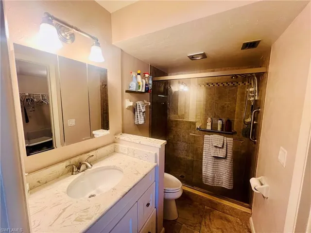 a bedroom with a bed a chandelier and a chair