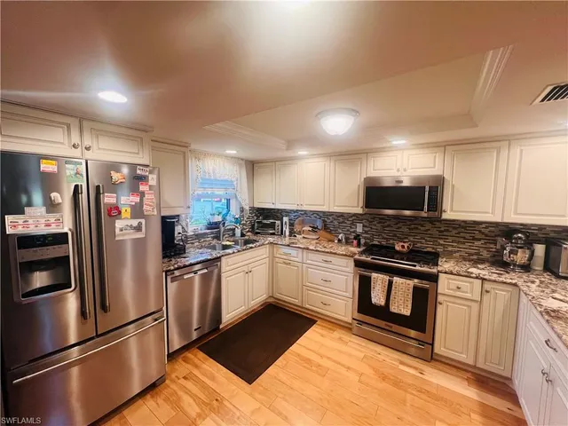a kitchen with stainless steel appliances granite countertop a stove a sink and a refrigerator
