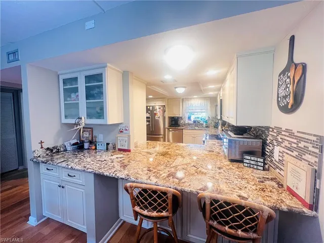 a kitchen with granite countertop cabinets stainless steel appliances and a counter space