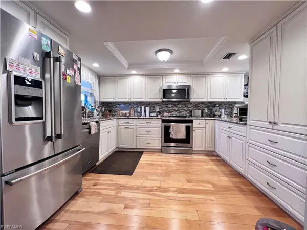 a kitchen with stainless steel appliances granite countertop a stove a sink and a refrigerator