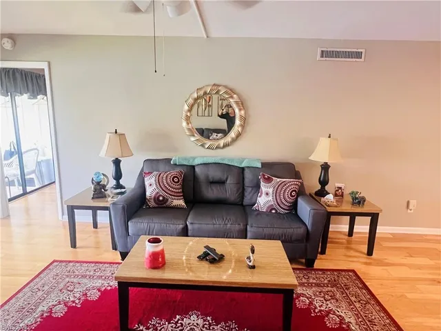 a living room with furniture a rug and a flat screen tv